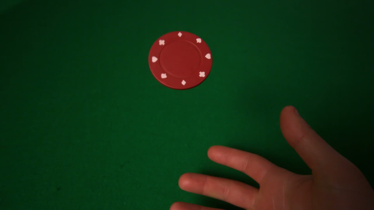 Hand flipping red casino chip