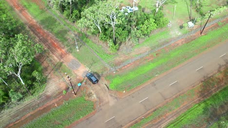 Luftdrohne-Eines-Autos,-Das-In-Eine-Unbefestigte-Schotterstraße-Einfährt,-Die-Zu-Einem-Haus-Im-Wald-Outback-Führt,-Verfolgung-Des-Abstiegs