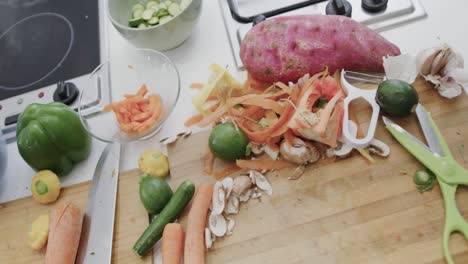 cuencos, tablas de cortar y bandeja de hornear de verduras picadas en la encimera de la cocina, en cámara lenta.