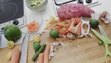 bowls, chopping boards and baking tray of chopped vegetables on kitchen countertop, slow motion