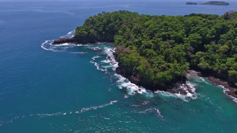 Forward-Low-Aerial-of-Rocky-Coastline-with-Blue-Water-Waves-Crashing