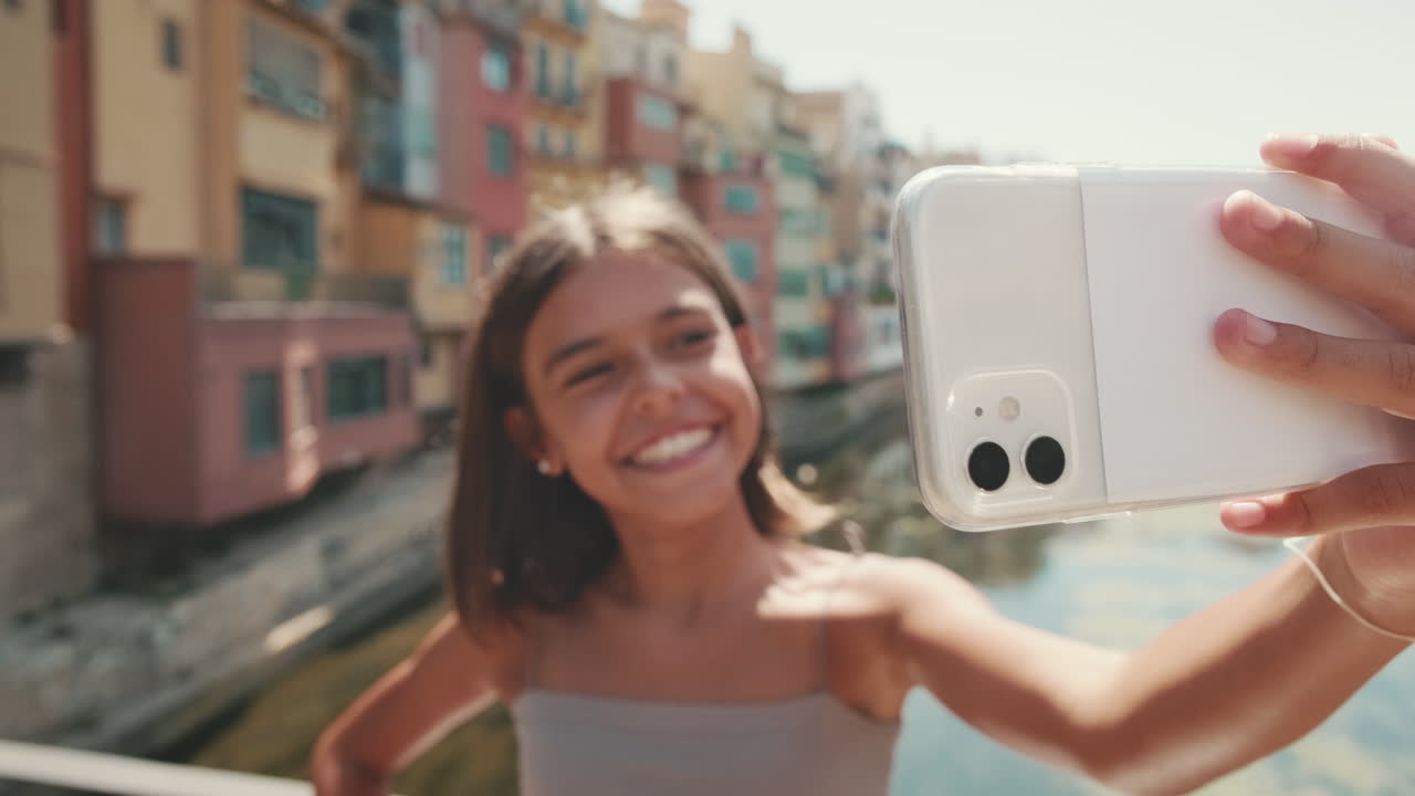 Menina feliz tirando uma selfie com um smartphone em uma cidade europeia
