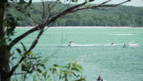 Motorboat-Traveling-In-The-Deep-Ocean-From-The-Distance-In-Background-With-Lush-Green-Mountains---Wide-Shot