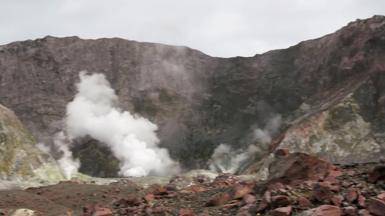panorámica hacia el campo geotérmico de la isla blanca con humo, whakaari