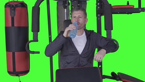 mature man drinking water on gym machine