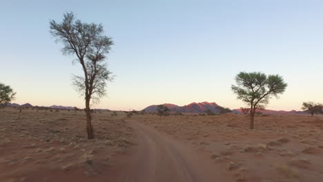 driving in the desert of namibia during sunset