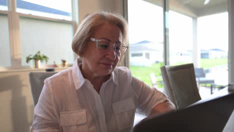 older-senior-citizen-comes-to-terms-with-the-news-concerning-a-relative-while-reading-her-email-in-the-morning-on-her-laptop-computer