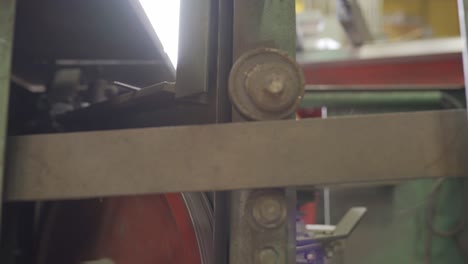 primer plano de una hoja de sierra girando sobre una sierra de cinta industrial
