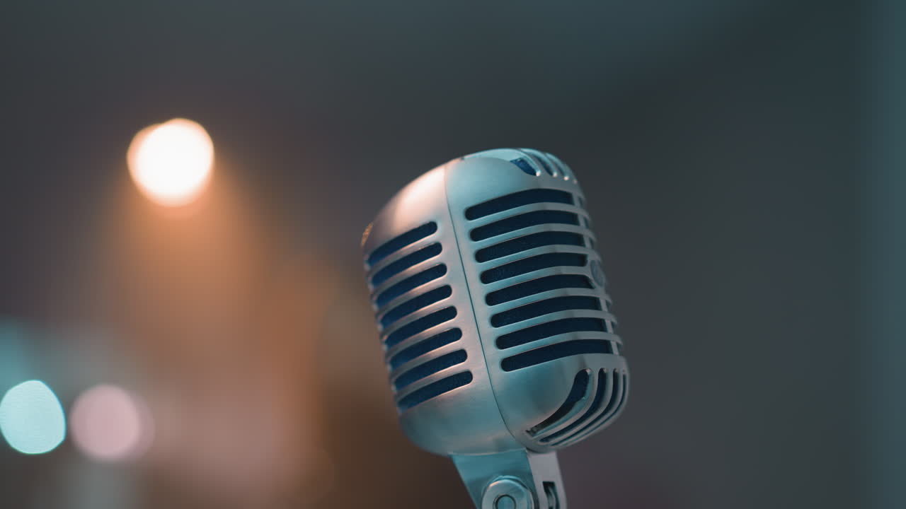 primo piano di un microfono vintage con uno sfondo sfocato, catturando un'atmosfera nostalgica e classica. la messa a fuoco morbida sullo sfondo aggiunge un senso di profondità e atmosfera alla scena