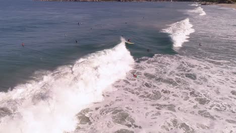 aerial shot of a surfer surfing a tube barrel wave with a rainbow in zicatela beach puerto escondido, oaxaca