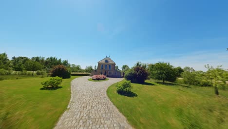 drone fpv volando a través del jardín hacia la casa en el campo de los países bajos