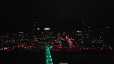 aerial drone's panning view over city landscape with lights and skyscrapers