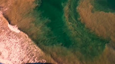 Luftaufnahme-Von-Schlammigem-Wasser,-Das-In-Den-Ozean-Fließt