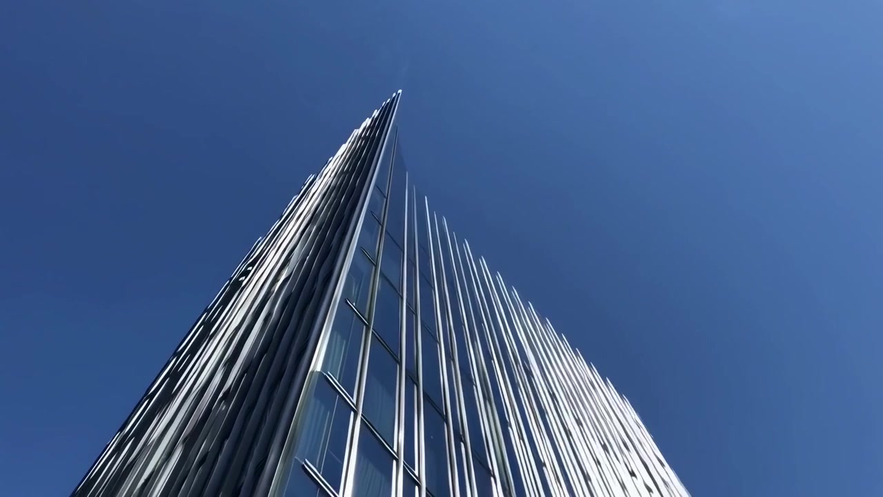 Low Angle View of Modern Glass Skyscraper Against Blue Sky