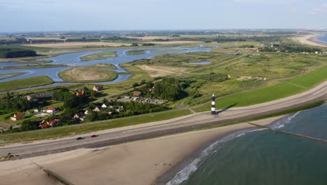 aerial seaside approach to the lighthouse situated onshore with the panorama of waterdunes - a nature area and recreational park in the province of zeeland, the netherlands