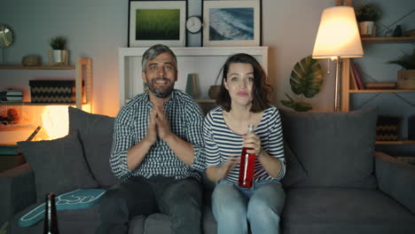couple enthusiastically watching a sporting event