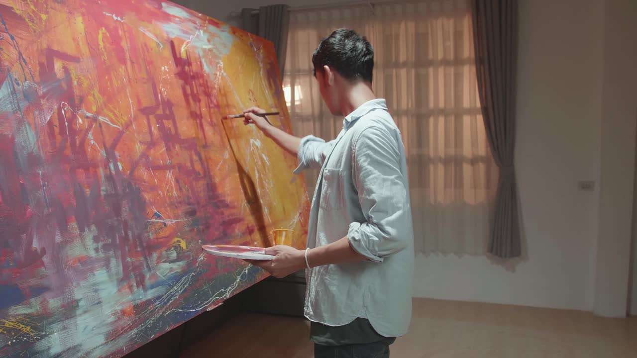 Male Artist Works On Abstract Painting, Moving Paint Brush Energetically He Creates Modern Masterpiece