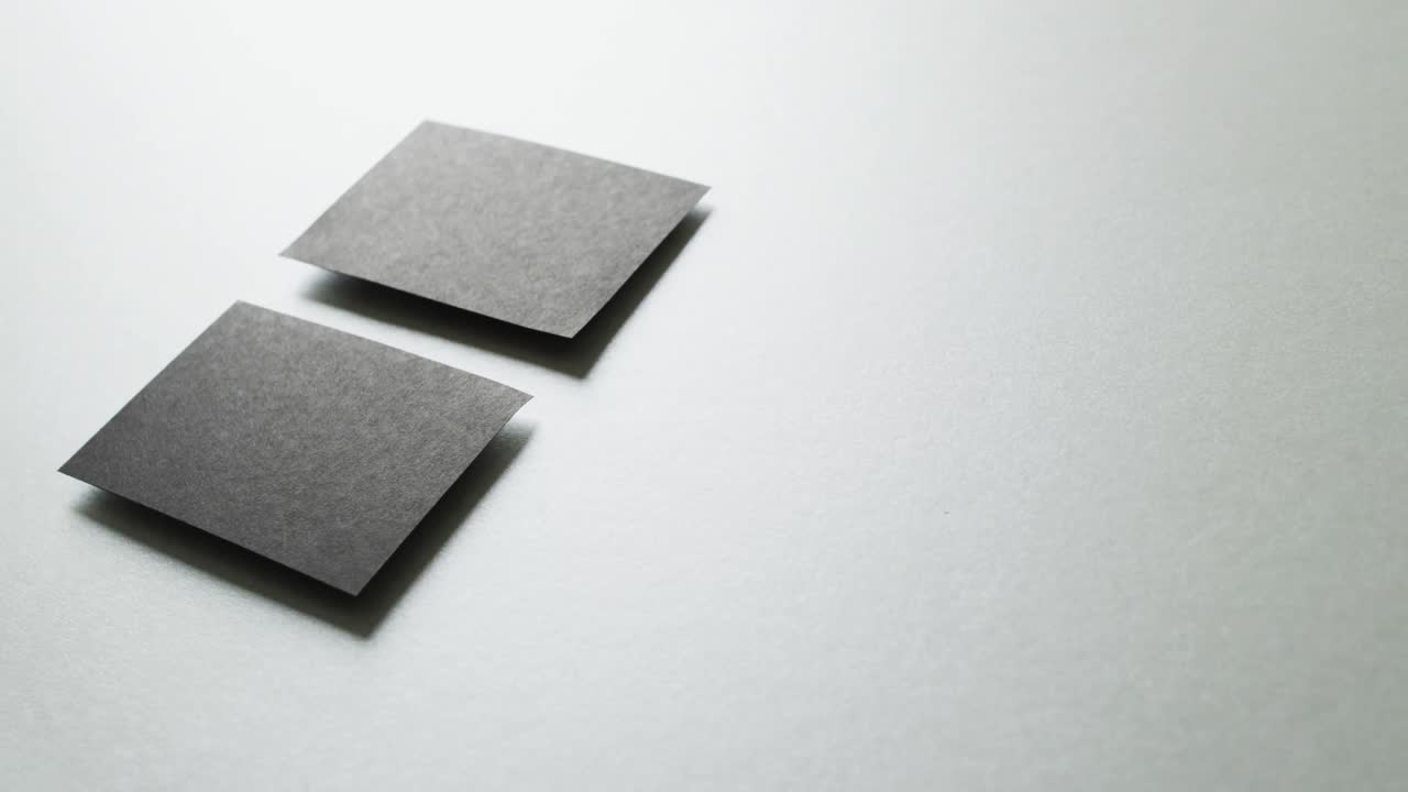회색 배경에 배열된 두 개의 검은색 비지니스카드의 클로즈업, 복사 공간, 느린 동작