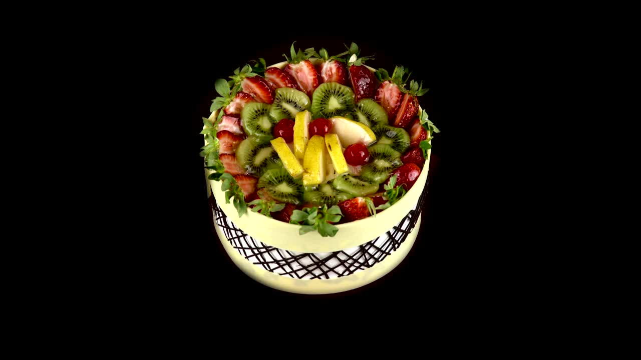 과일 케이크가 검은 배경으로 돌아갑니다.