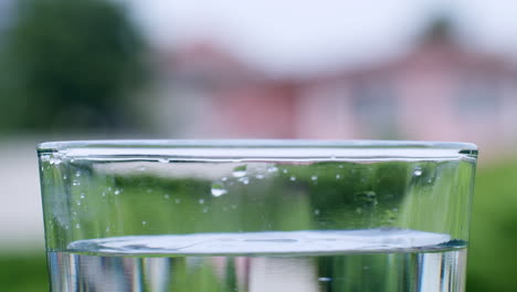 ripples and waves formed by droplets of liquid that fall into a glass filled with water