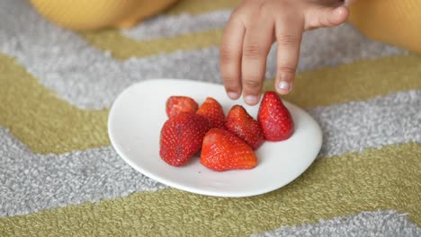 child eating strawberries