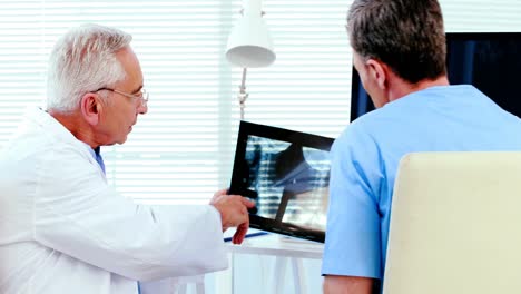 Male-doctor-discussing-x-ray-report-with-a-patient