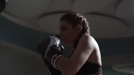 young attractive woman in boxing gloves training with her couch in a boxing club. slow motion shot