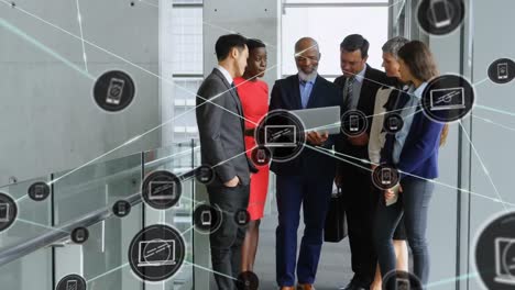 animation of connected icons by lines, diverse coworkers discussing reports over laptop in corridor