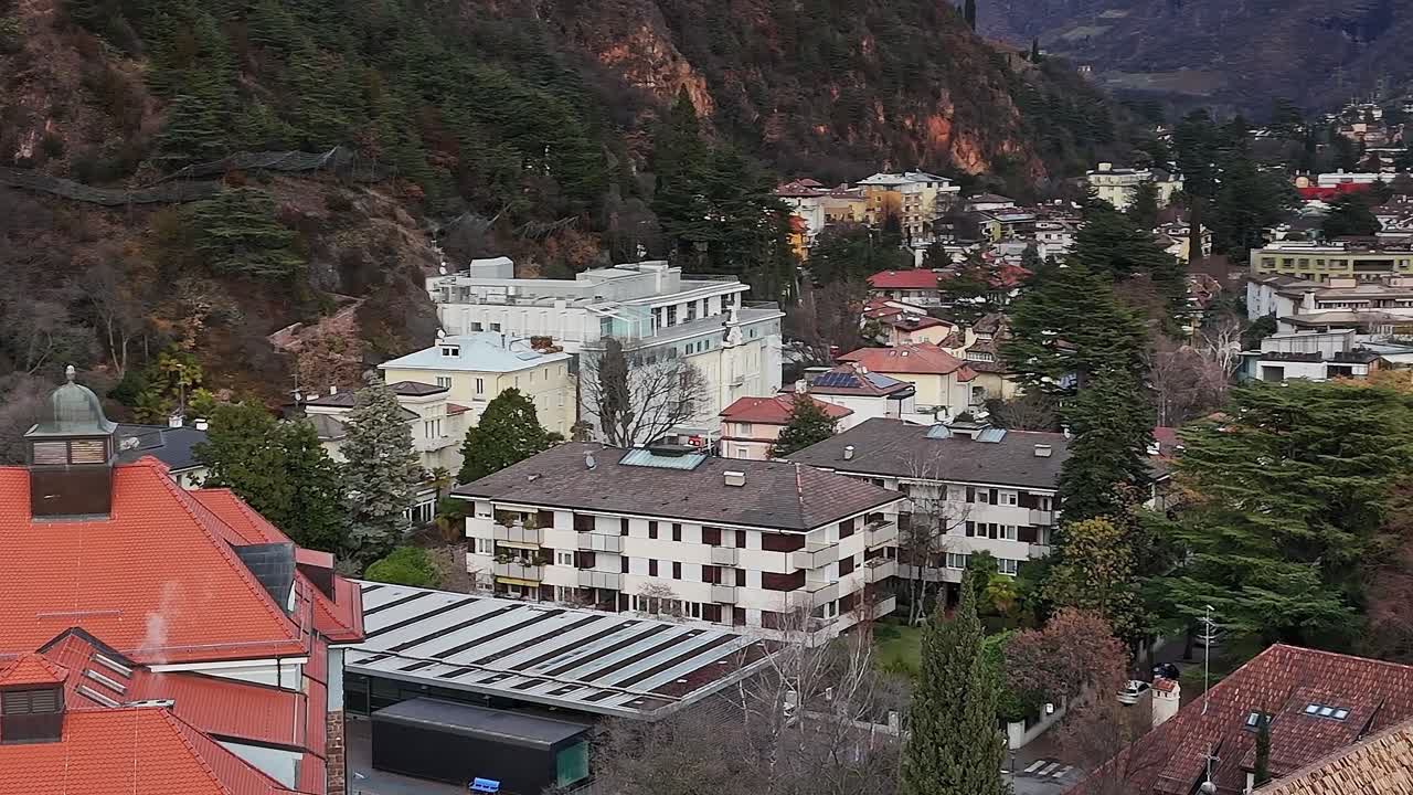 Vista di edifici sulle Alpi italiane circondati da montagne e alberi