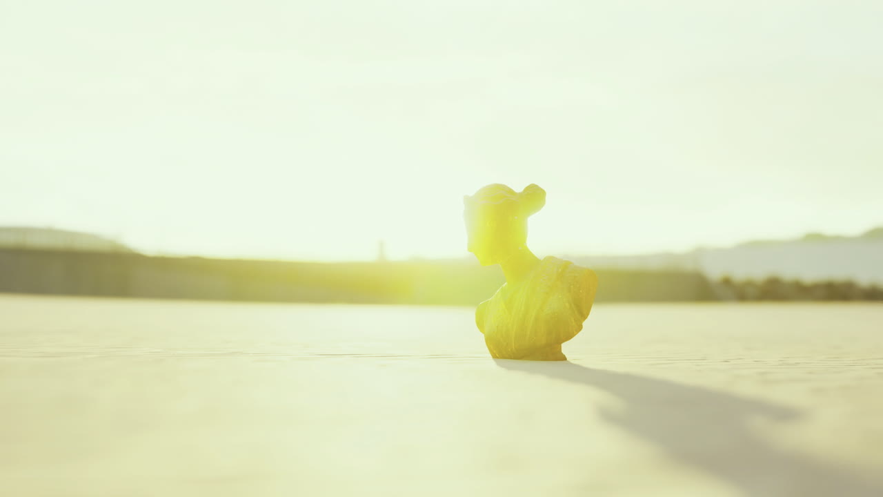 Emerging silhouette of a bust under golden sunlight at dusk