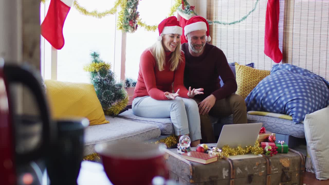 feliz pareja caucásica madura haciendo una videollamada en una habitación llena de decoraciones de navidad