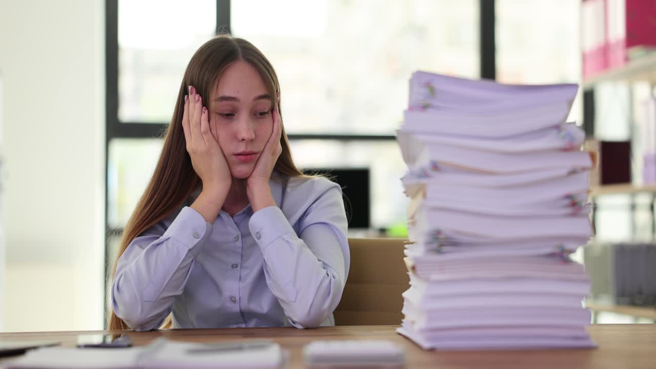 Overwhelmed woman with a stack of paperwork