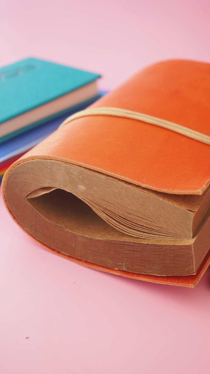 Close Up of an Old Rustic Notebook on a Pink Background