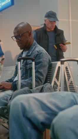 man working on laptop in airport