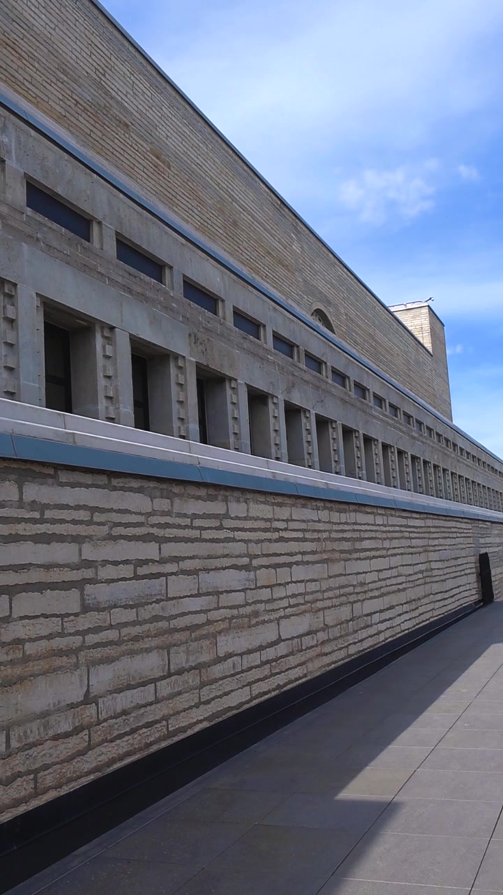 Arquitectura modernista de piedra de la recientemente renovada Biblioteca Nacional de Estonia en Tallin, con su distintiva fachada bajo un cielo azul brillante en un soleado día de verano