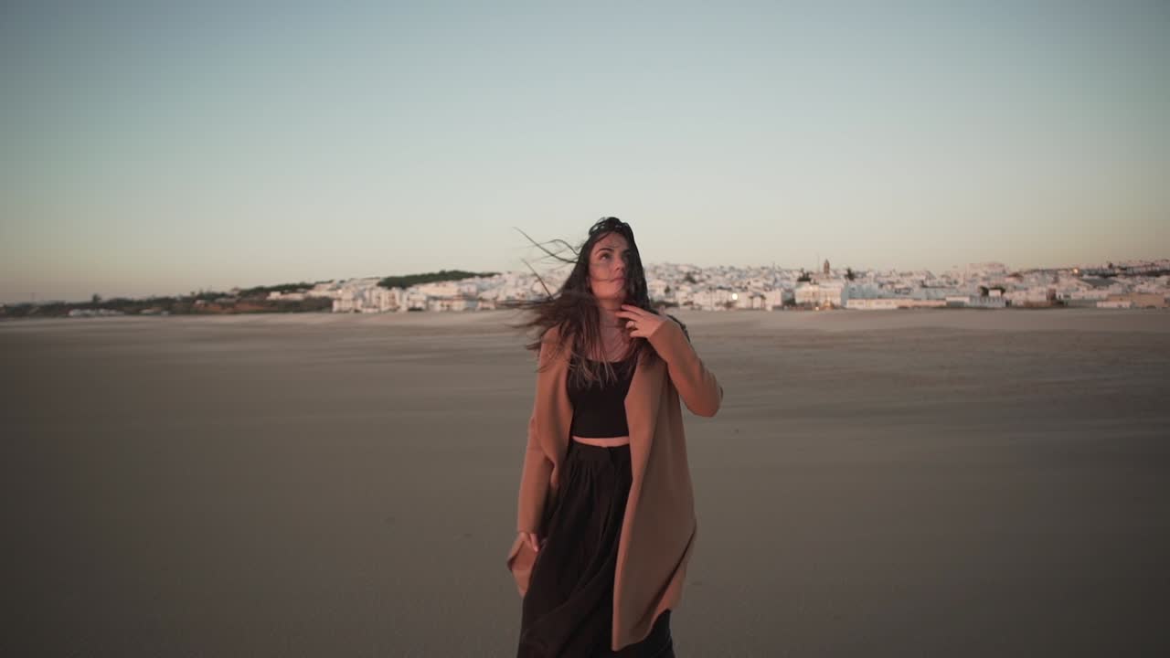 Tender woman on seashore on windy day