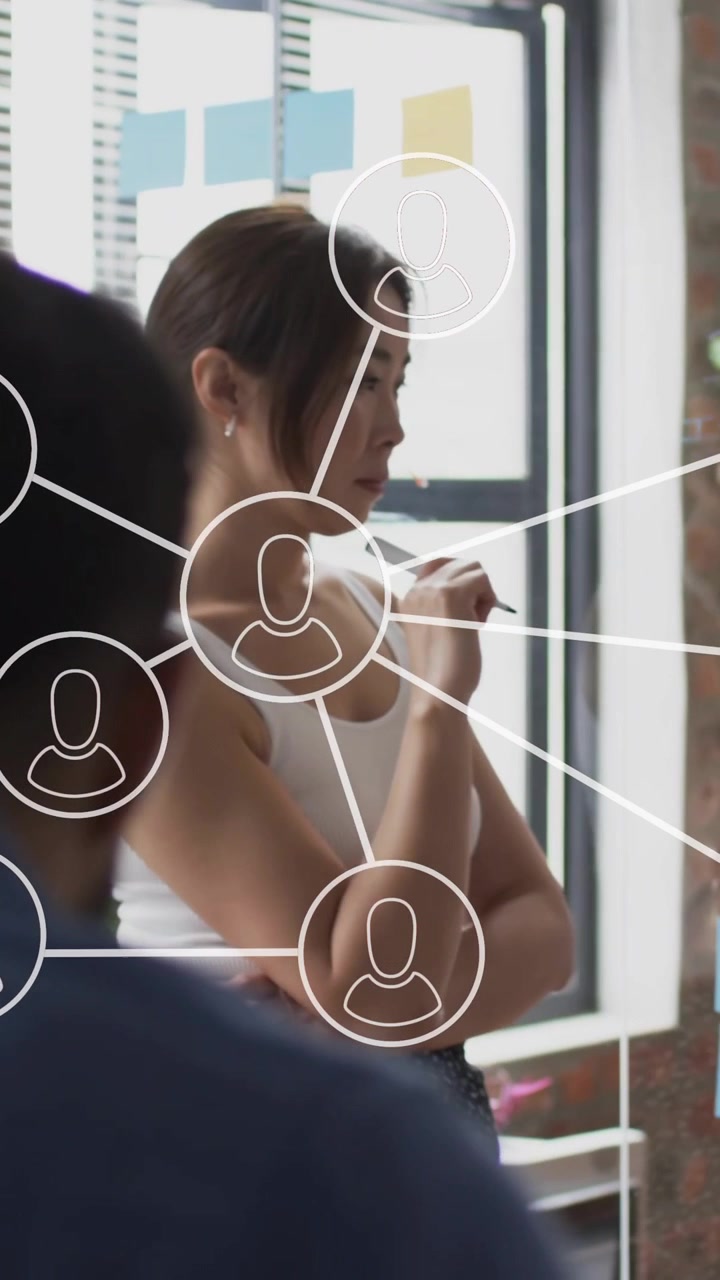 Animation of network of connections with icons over diverse colleagues at meeting in office
