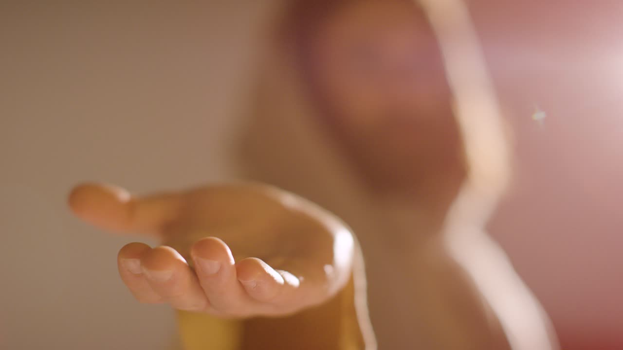 fotografía retroiluminada de un hombre con cabello largo y barba que representa la figura de jesucristo extendiendo la mano en amistad hacia la cámara