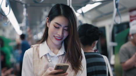 mujer usando un teléfono inteligente en un tren del metro