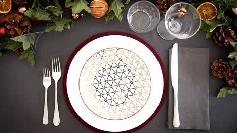 overhead view of a place setting at a christmas dinner table with christmas cracker, jump cut