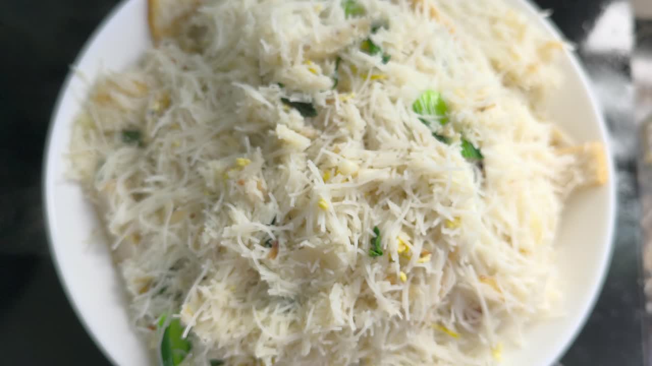 Kokken steger bihun (risnudler) blandet med grøntsager, æg og krydderier. Denne smagfulde ret er en populær malaysisk spise, der ofte serveres som et hurtigt måltid.