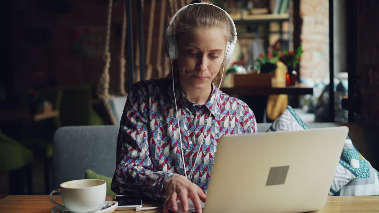 Woman Working on Laptop in a Coffee Shop