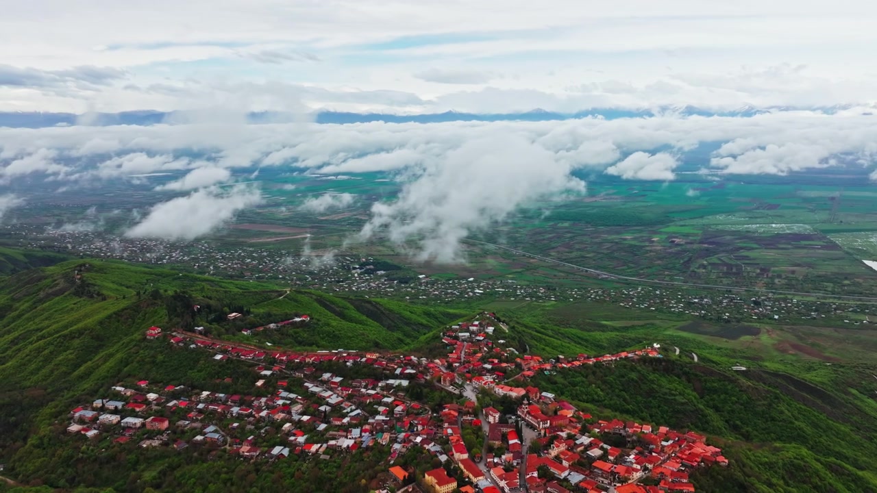 Prospettiva aerea da drone elevata di Sighnaghi, Georgia, con luce dorata su edifici storici e ampie vedute della valle.