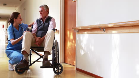 enfermera hablando con su paciente en silla de ruedas