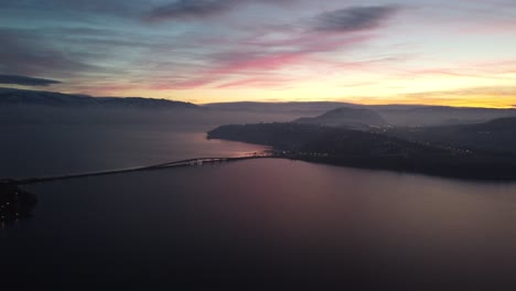 Toma-De-Drones-Del-Puente-West-Kelowna-En-El-Lago-Okanogan-Con-Puesta-De-Sol