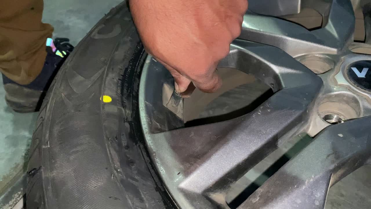 mecánico de cerca inflando el neumático y comprobando la presión del aire con la presión del medidor en la estación de servicio