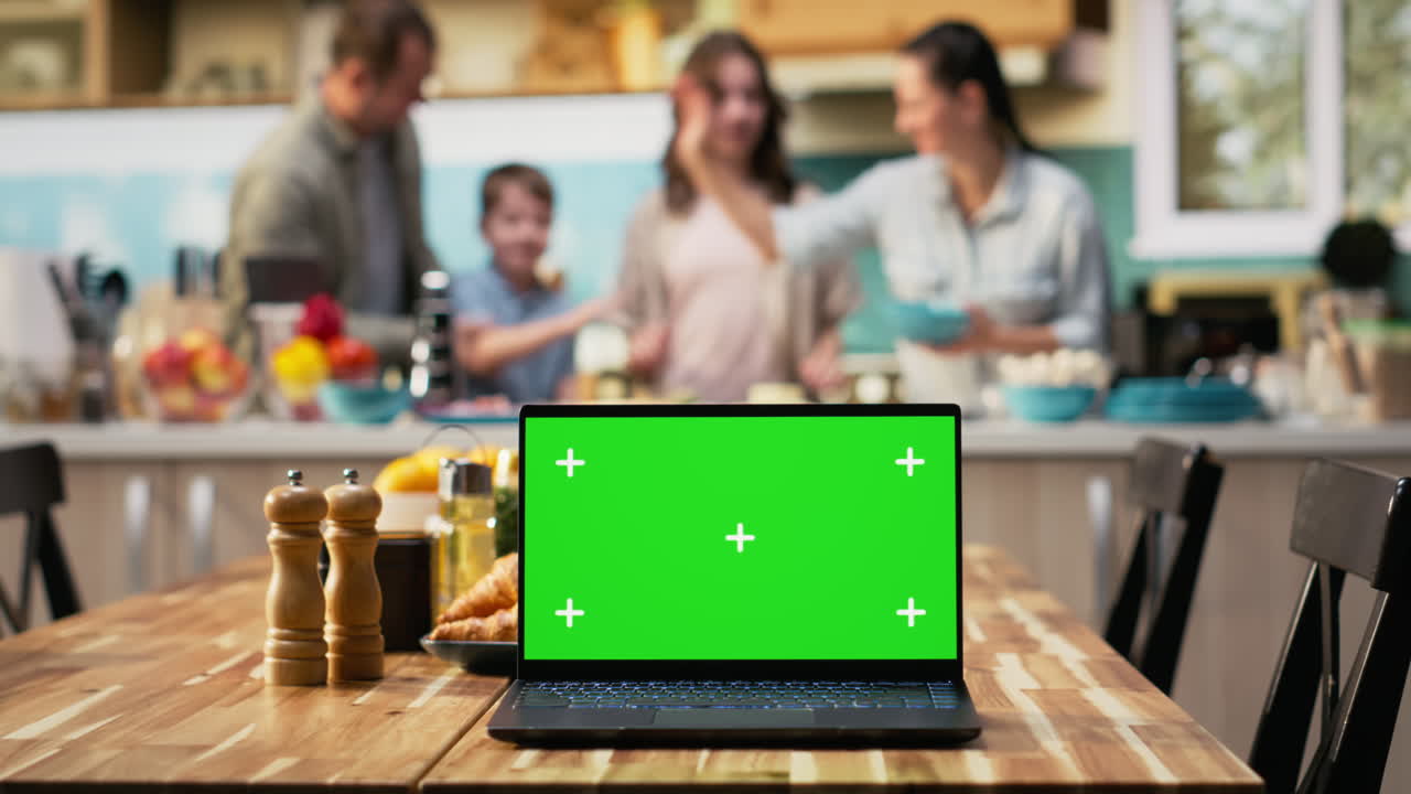 Green screen next to parents and kids having fun in the kitchen