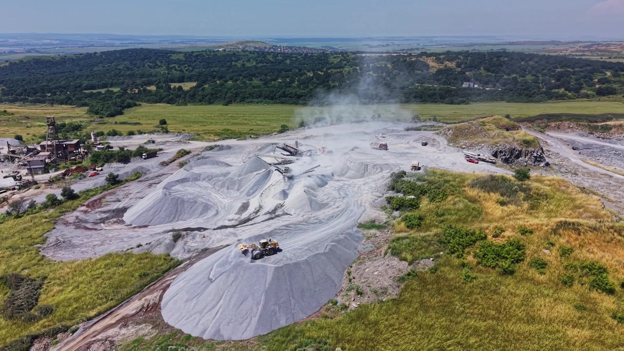 Tunga maskiner arbetar på en plats för att utvinna mineraler på ett öppet område