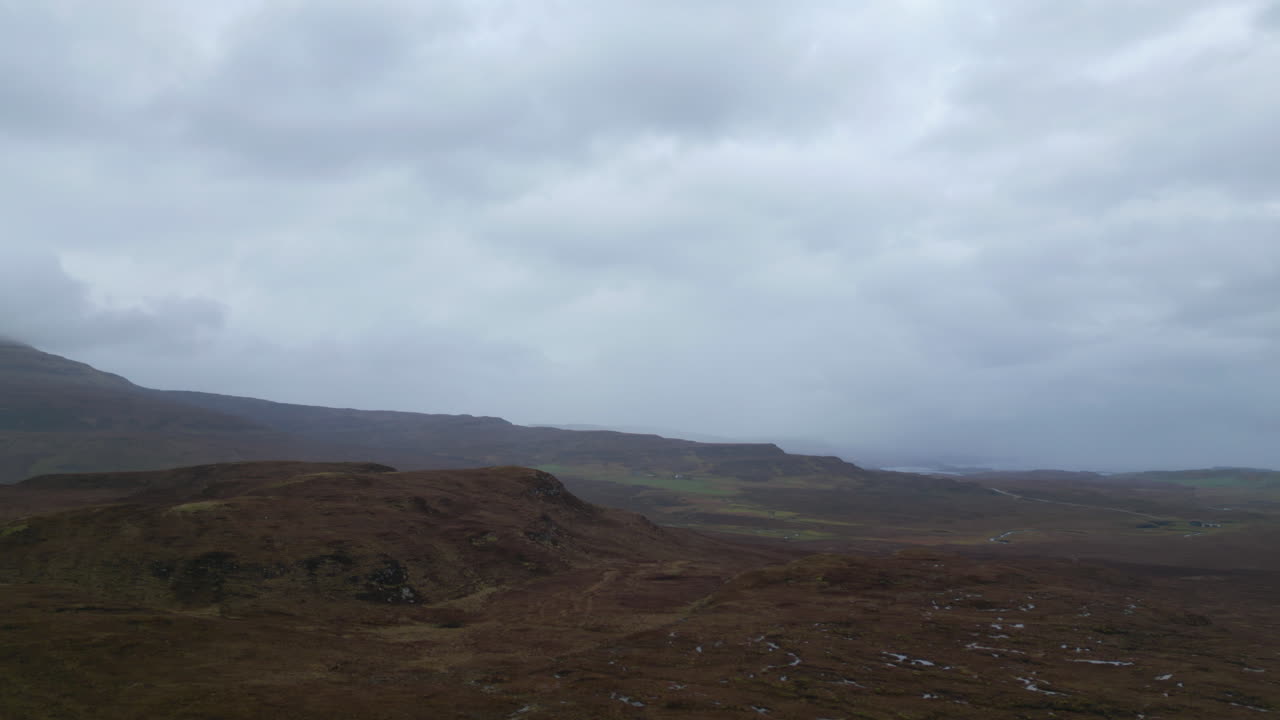 Aerial trucking view over the mountains of Isle of Skye on a cloudy day