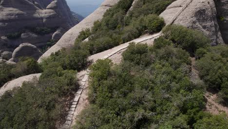 drone órbita después del descenso de una joven en el medio del parque natural de la montaña de montserrat en barcelona, españa, concepto de cinematográfico, naturaleza y estilo de vida